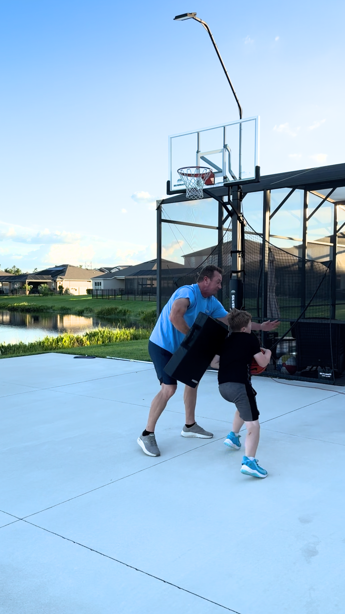 Coach helping athlete with resistence in a basketball move.